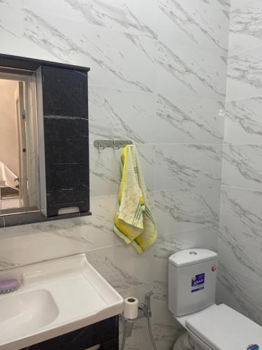 a white bathroom with a sink and a toilet at Гостевой дом in Pokrovka