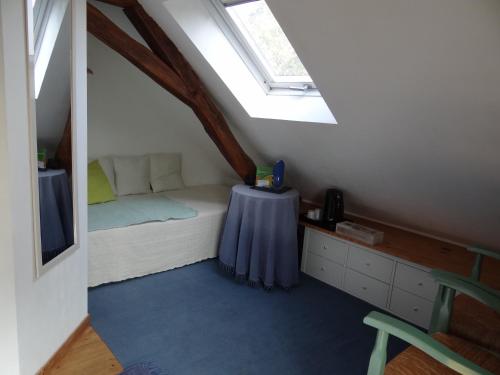 a bedroom with a bed with a table and a skylight at Au Moulin Géant in Rochefort-sur-Loire