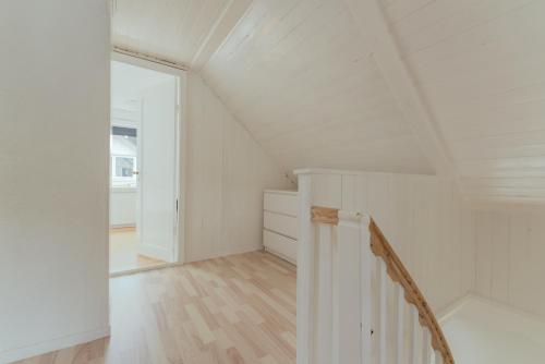 a white attic room with a staircase and a door at Charming 2BR Retreat in Vestmanna in Vestmanna
