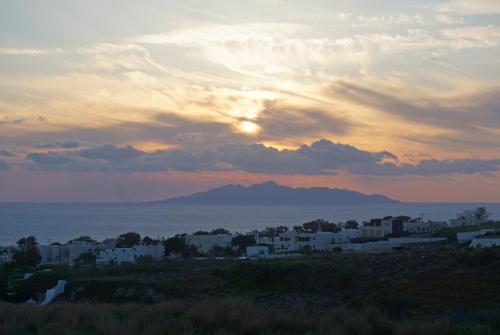 a sunset over a city with a mountain in the background at Golden moments Luxury Stone Villas A in Mesaria