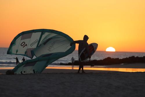 a man standing on the beach with a kite at Océan Vagabond Lassarga in Dakhla