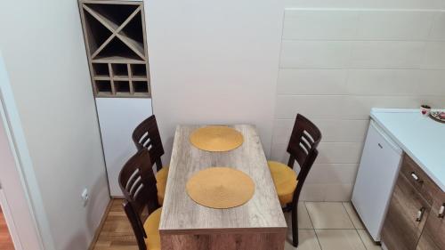 a wooden table with four chairs in a kitchen at Apartmani Simić Quatro in Valjevo