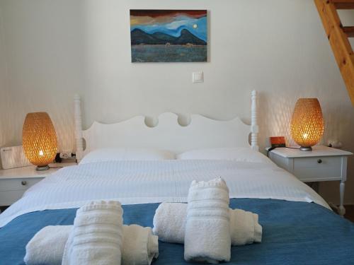 a bedroom with a white bed with towels on it at Hydra Memories House in Hydra