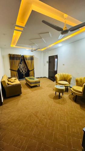 uma sala de estar com sofás e cadeiras e um tecto em Rahat villas apartment em Islamabad
