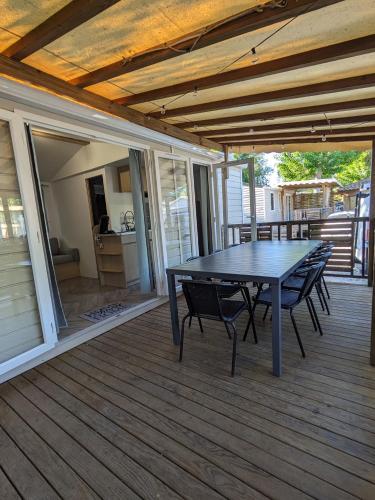 un patio avec une table et des chaises sur une terrasse dans l'établissement La Carabasse Les Mazets 101, à Vias