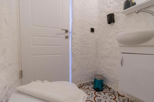 a white bathroom with a toilet and a sink at Das Hotel Alacati in Alaçatı