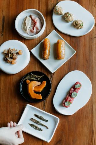a table topped with white plates with different types of food at Ca' Nadin Agriturismo in San Damiano dʼAsti