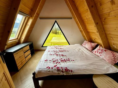 a bedroom with a bed with red flowers on it at Villa Una & sauna in Vlasic