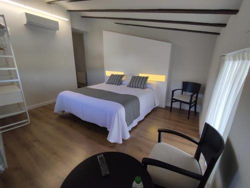 a bedroom with a bed and a chair at Hotel La Vera Cruz in Caravaca de la Cruz