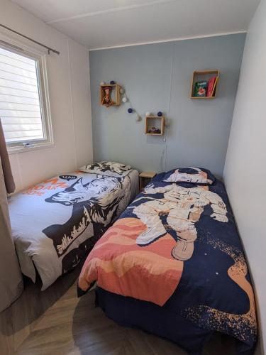 une chambre avec deux lits et une fenêtre dans l'établissement La Carabasse Les Mazets 101, à Vias