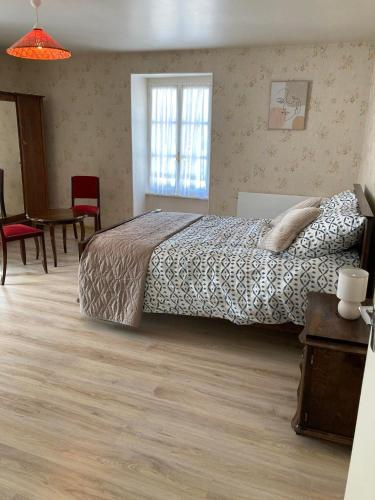 une chambre avec un lit, une table et des chaises dans l'établissement Le gîte de Rose, à Pusy-et-Épenoux