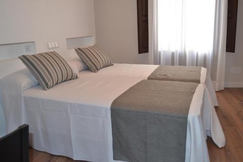 a bedroom with a large white bed with pillows at Hotel La Vera Cruz in Caravaca de la Cruz
