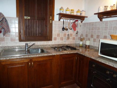 a kitchen with a sink and a microwave at Villa dei Pini , Solanas Villasimius in Solanas