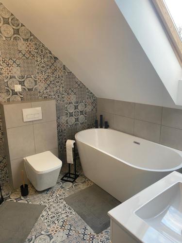 a bathroom with a tub and a toilet and a sink at Zielnisko in Firlej