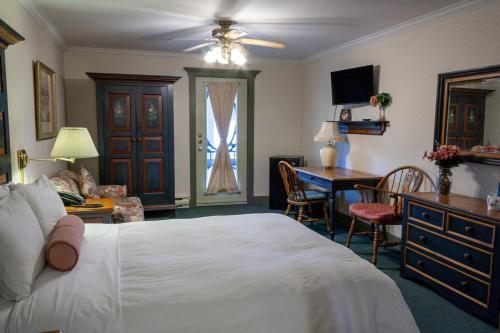 a bedroom with a bed and a desk and a table at Auberge Lakeview Inn in Lac-Brome
