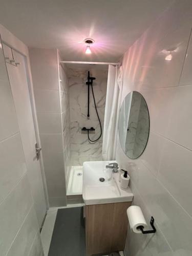 une salle de bain blanche avec un lavabo et un miroir dans l'établissement Perle au milieu du Panier avec Terrasse Magnifique, à Marseille