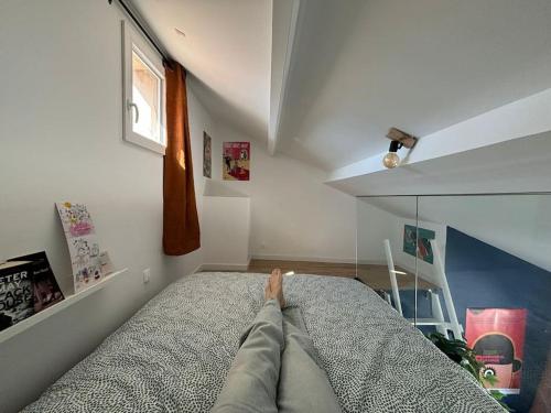 une personne dormant sur un lit dans une pièce dans l'établissement Perle au milieu du Panier avec Terrasse Magnifique, à Marseille