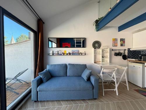 un salon avec un canapé bleu et une table dans l'établissement Perle au milieu du Panier avec Terrasse Magnifique, à Marseille