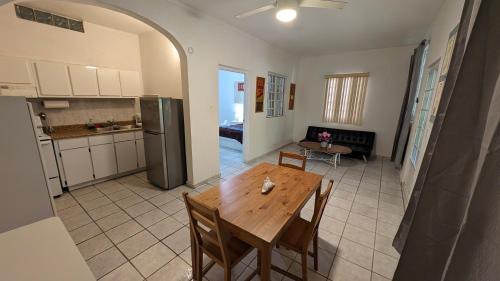 a kitchen and dining room with a wooden table and chairs at Yukayeke Playa Resort in Anasco