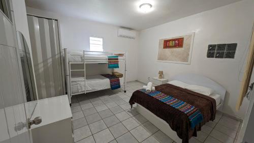 um quarto com uma cama e um beliche em Yukayeke Playa Resort em Añasco