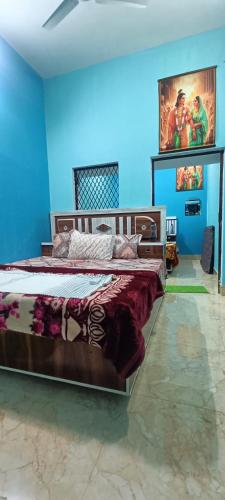 1 dormitorio con 2 camas y pared azul en Kishori ram guest house 5 minute walking distance from railway station en Ayodhya