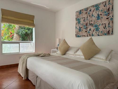 a bedroom with a large bed with a painting on the wall at Hotel Los Palomos in Lunahuaná