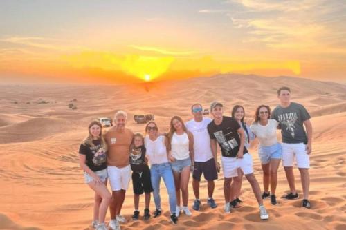 a group of people standing in the desert at Sunset Camp Merzouga in Merzouga