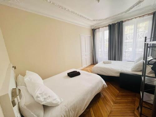 une chambre d'hôtel avec deux lits et une échelle dans l'établissement Appart d'exception Quai de seine, à Paris