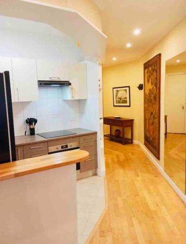 une cuisine avec des armoires blanches et un plancher en bois dans l'établissement Appart d'exception Quai de seine, à Paris