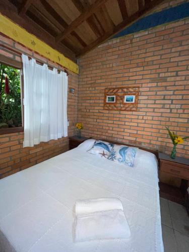 ein Schlafzimmer mit einem großen Bett mit Handtüchern darauf in der Unterkunft Morada Crisálida in Praia do Rosa