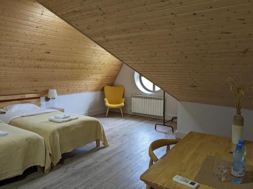 a bedroom with two beds and a yellow chair at Begaso Family Winery in Kvareli