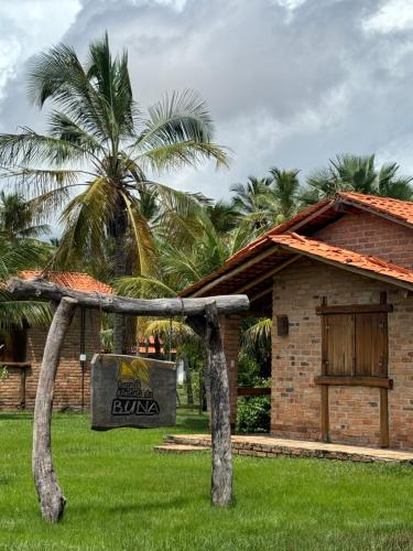 een bord voor een gebouw met palmbomen bij Rancho do Buna in Atins