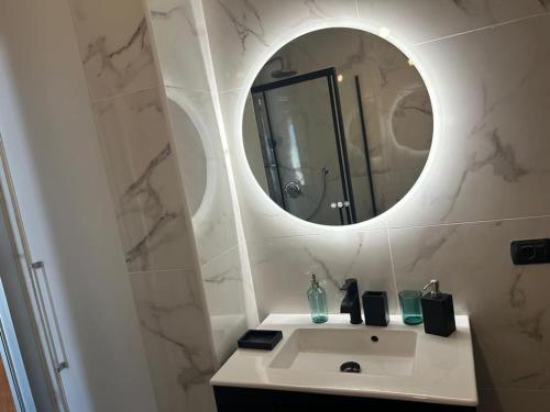 une salle de bain avec un lavabo blanc et un miroir dans l'établissement Lovely Stay in Roquebrune-Cap-Martin With See View, à Roquebrune-Cap-Martin