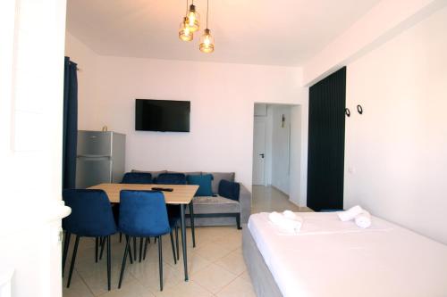 a room with a bed and a table and chairs at Omnia Apartments in Ksamil