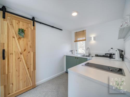 a kitchen with a sliding barn door in a kitchen at Zöld Ajtós Ház in Gárdony