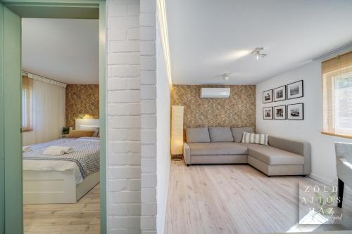 um quarto e uma sala de estar com um sofá e uma cama em Zöld Ajtós Ház em Gárdony