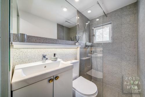 a bathroom with a sink and a toilet and a shower at Zöld Ajtós Ház in Gárdony