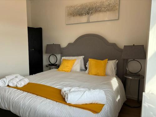 a bedroom with a large bed with yellow pillows at Flat 306 Beautiful one bed flat in Birmingham