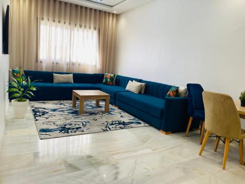 a living room with a blue couch and a table at Glorious NOUACEUR in Nouaceur