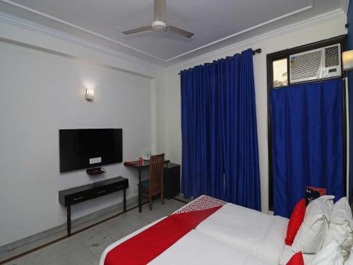 1 dormitorio con 1 cama y TV de pantalla plana en Golden Cafe en Chennai
