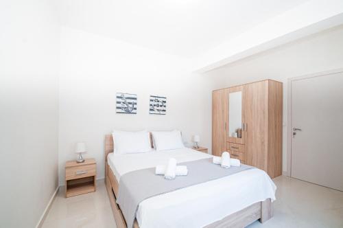 1 dormitorio blanco con 1 cama y armario de madera en Asterashouse en Rodas