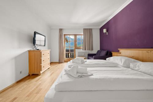 1 Schlafzimmer mit 2 Betten und einer lila Wand in der Unterkunft Apartment Select TOP 8 - by Four Seasons Apartments in Piesendorf
