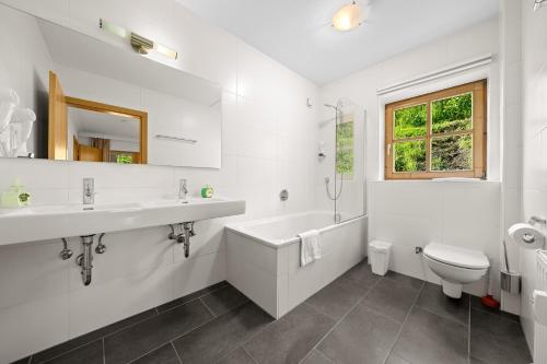 ein weißes Badezimmer mit einer Badewanne, einem Waschbecken und einem WC in der Unterkunft Apartment Select TOP 8 - by Four Seasons Apartments in Piesendorf