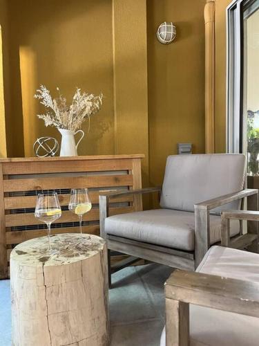 a living room with a chair and wine glasses on a stump at Bear Lodge, Whistler Village - Spectacular Location on Village Stroll, Designer Remodel in Whistler