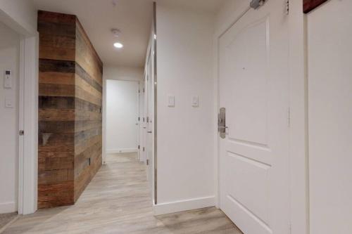 a hallway with a white door and a wooden wall at Bear Lodge, Whistler Village - Spectacular Location on Village Stroll, Designer Remodel in Whistler