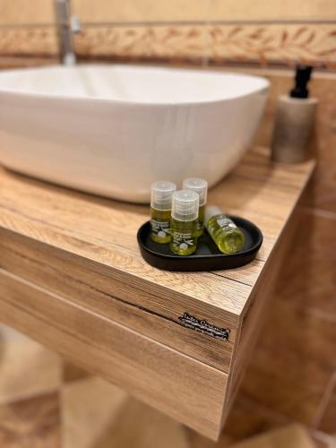 a black plate with two jars on a counter next to a sink at Premium Suites in Stara Zagora