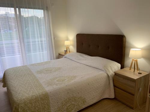 une chambre avec un lit et deux lampes et une fenêtre dans l'établissement Superbe 2 pièces moderne refait à neuf, PISCINE !, à Antibes