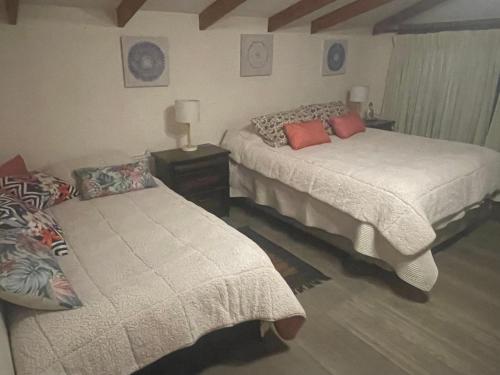 Casa el mesias في سانتياغو: غرفة نوم بسريرين وطاولة بها مصباح