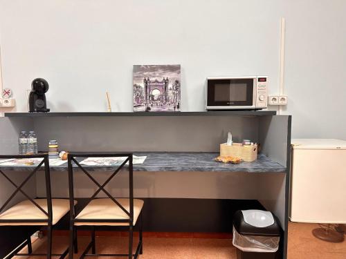 a desk with two chairs and a microwave in a room at stop & go in Arbós