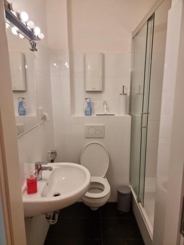 a white bathroom with a toilet and a sink at غرفة مميزة في موقع مميز in Bonn
